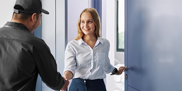 HVAC technician greeting a homeowner at the door