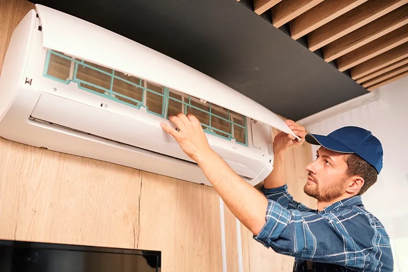 An HVAC technician inspecting a ductless unit