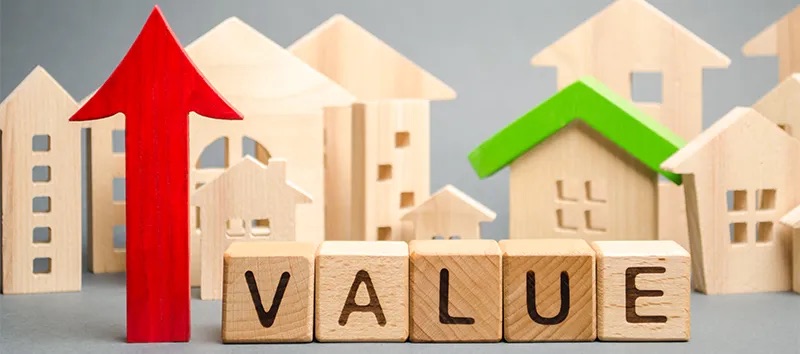 Wooden houses with the word value and a red arrow pointing up