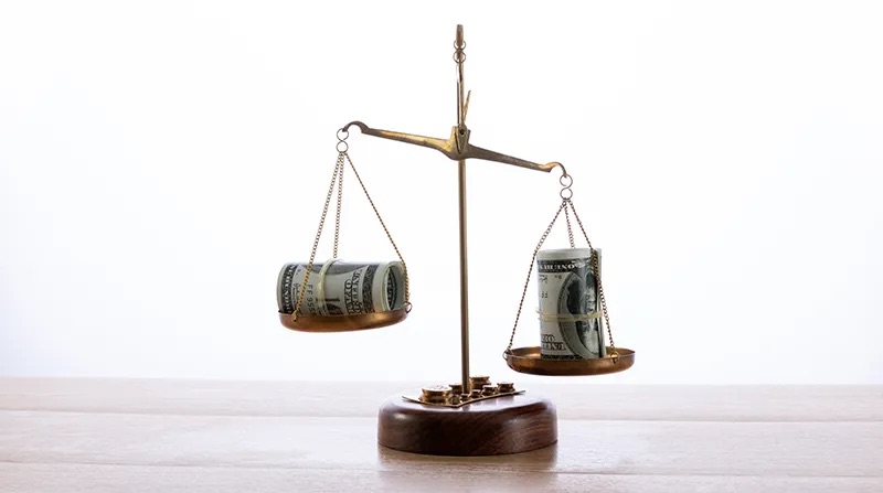 Money balancing on a scale