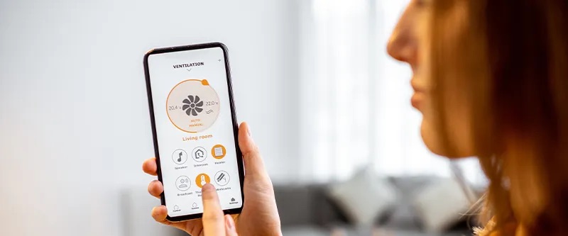Woman using a smartphone app to control her HVAC system