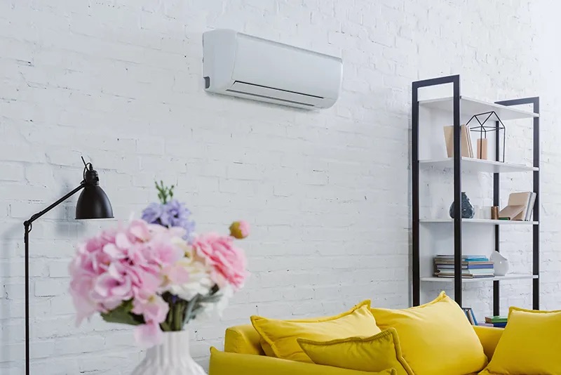 A ductless heat pump indoor head mounted high on a wall in a modern room